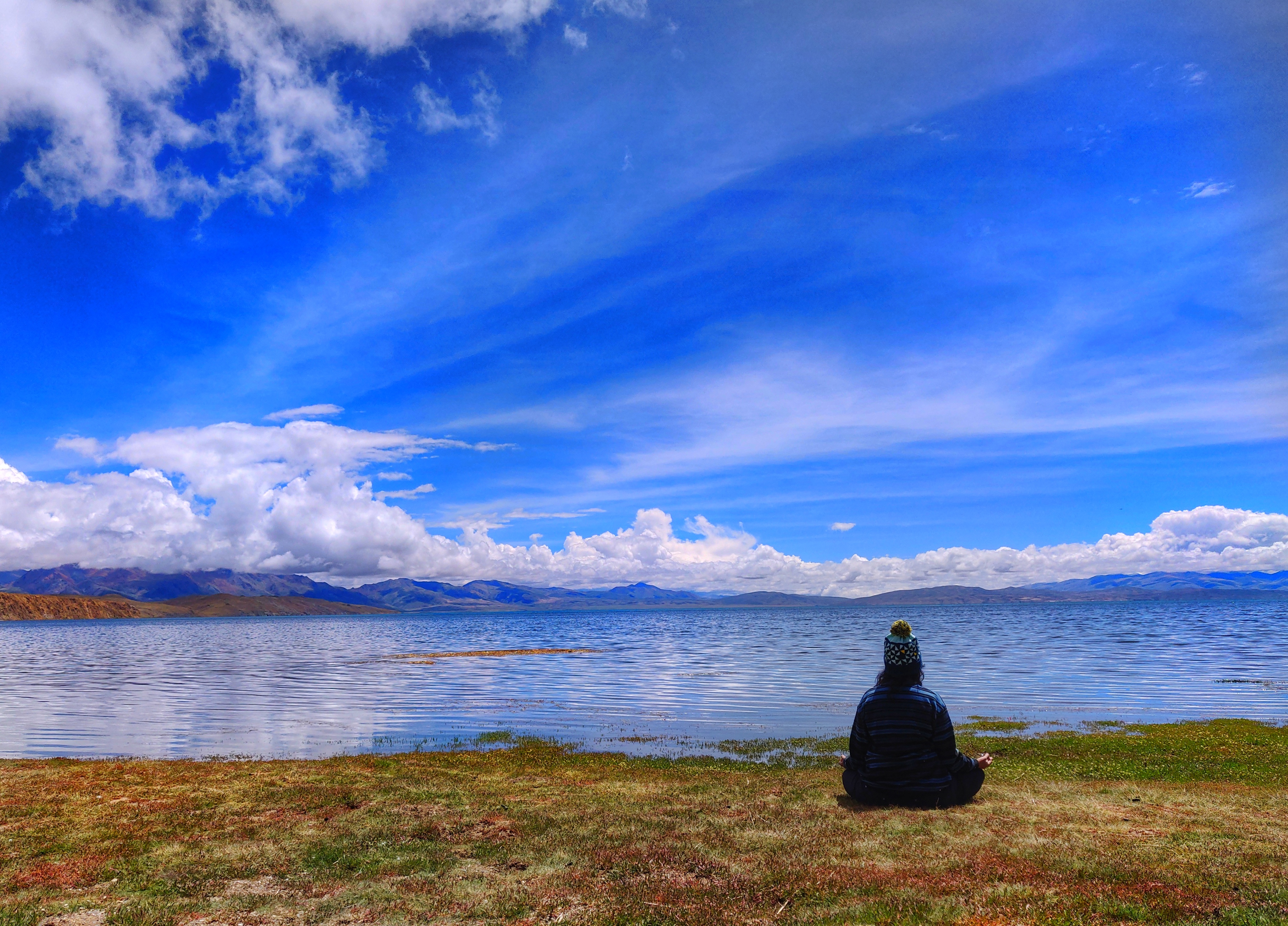 I am sitting by the side of Lake Mansarovar during Kailash Mansarovar Yatra